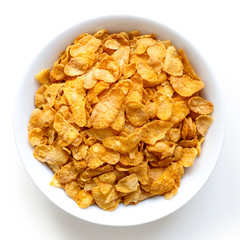 Bowl of dry cornflakes isolated on white from above.