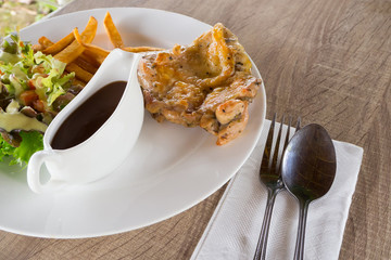 Dining table with Chicken steak and Vegetables Salad.