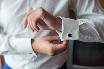 The man in the white shirt in the window dress cufflinks.