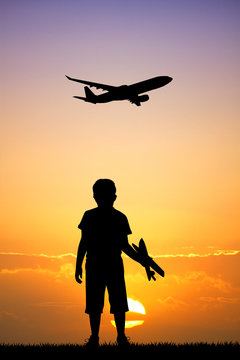 child with airplane at sunset