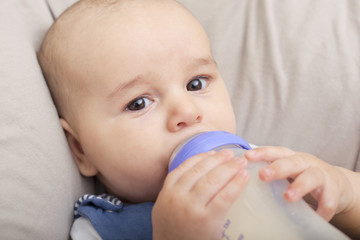 Baby boy drinking milk from the bottle