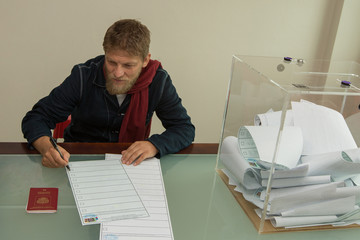 Man casts ballot in the ballot box. A man votes in the elections to the State Duma. Election...