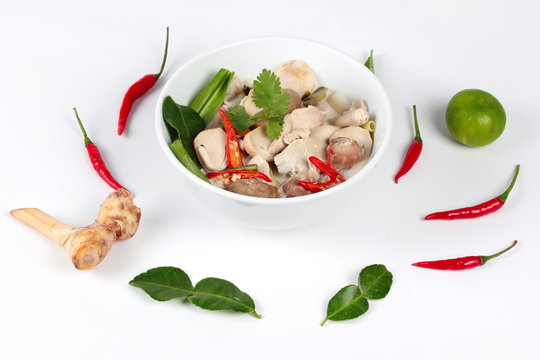 Chicken and galangal in coconut milk soup and herb on white background. Side view