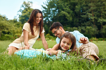 Fototapeta premium Happy Young Family In Park. Parents And Kids Having Fun, Playing