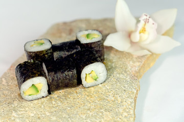 Avocado sushi roll on stone texture