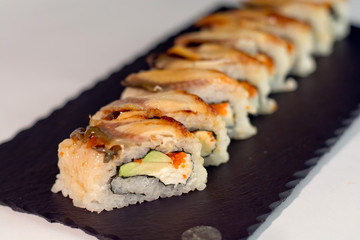 Eel sushi, decorated with sesame on slate texture close up