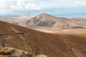 Beautiful volcanic mountains and the road on a mountain slope.  Road from la Pared to Betancuria . Fuerteventura. Canary Islands