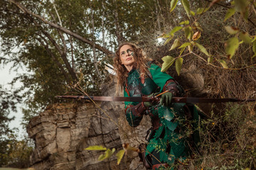 Naklejka na ściany i meble Elf woman in green leather armor with the bow and arrows