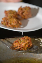 fried Indian pakora cooking over a pan