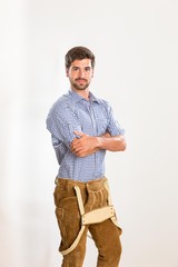 Junger Mann in Lederhosen hat seine Tr&auml;ger heruntergeklappt