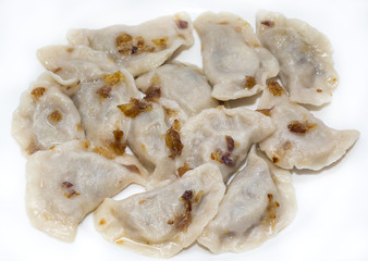 dumplings with cabbage and greens on a white plate in a restaurant