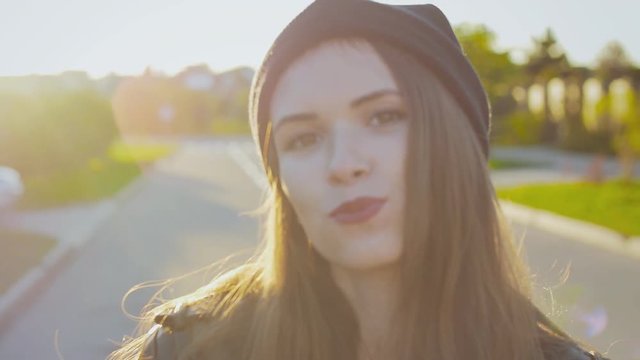 Hipster young girl posing in black hat at sunset