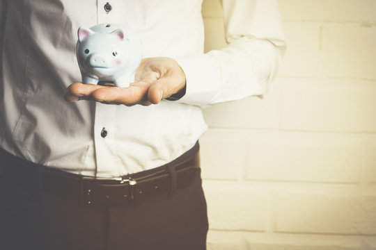 Business man holding a piggy banck