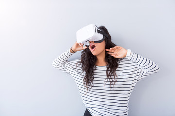 Positive young woman using virtual reality device