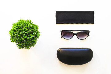 Sunglasses lying on a white table with a box and cloth