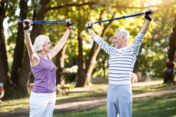Obraz premium Good productive physical training of elderly couple in summer park