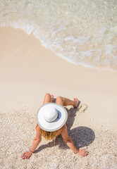 Young woman in white bikini looking at water
