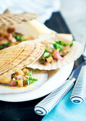 Scallops cooked in shells with croutons and served with lemon and chopped cilantro