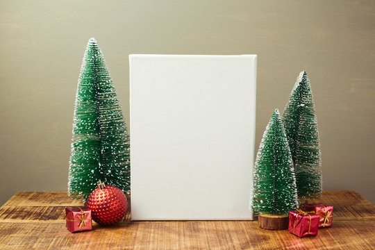 Christmas holiday mock up with canvas and pine tree on wooden table