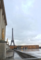 view of the Eiffel tower and Trocadero place with statue of Woman during a rainy day