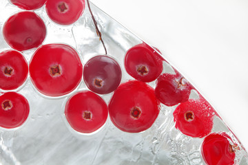 Frozen red berries. Forest cranberry in piece ice. macro view. copy space