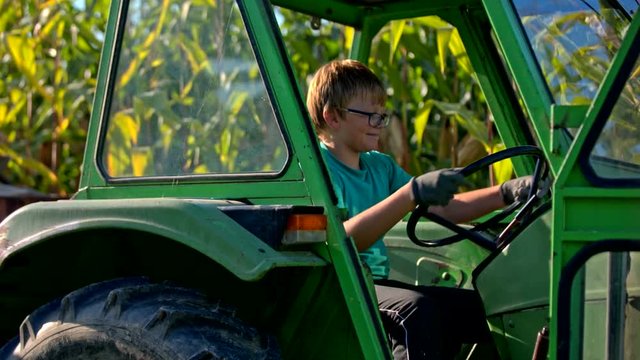 Boy holding tractor steering wheel and turning