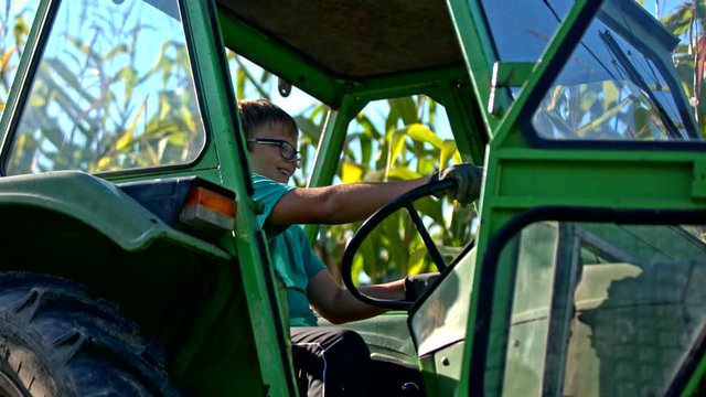 Boy on tractor turning steering wheel