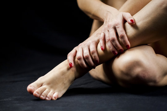 Woman hand and legs with dark background