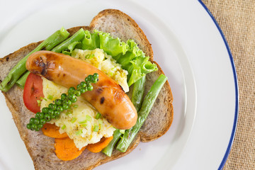 American breakfast, sausage and bread with vegetables in white d