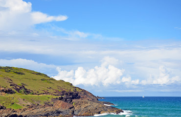 Grassy, rocky coastline and aqua waters of the Pacific Ocean near Coffs Harbour on the New South Wales coast, Australia 