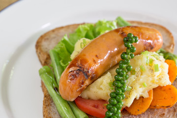 American breakfast, sausage and bread with vegetables in white d