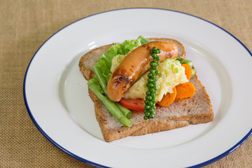 American breakfast, sausage and bread with vegetables in white d