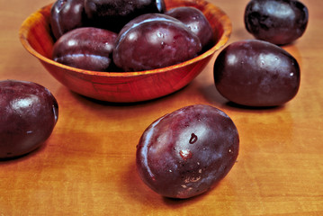 Ripe plums in a wooden bowl