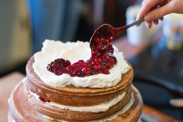 Naked cake hand toping whipped cream berries strawberry cooked birthday wedding homemade pastry