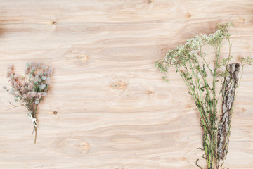 Dry flowers and herbs collage composition at wooden desk