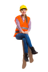 Smiling Female Construction Worket Sitting With Legs Crossed
