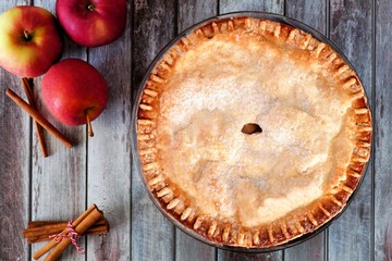 Delicious autumn apple pie, overhead table scene on a rustic wood background