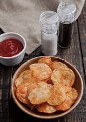 Bowl with potato crisps chips on wooden board