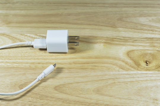 USB cable power adapter on wooden background.