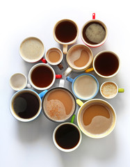 Cups of coffee on white background, top view