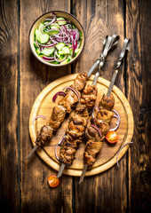 Kebab with fresh salad of cucumbers and onions.