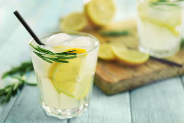 Cold fresh cocktail with lemon on wooden background