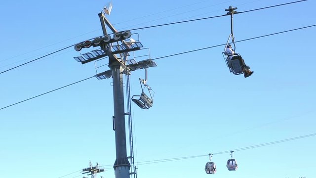 Lift transporting people and ski equipment up to the mountain. Sunny weather. Switzerland, Flums.