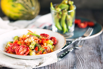 Vegetable stew with okra and shrimps in rustic composition – close up view with copy space