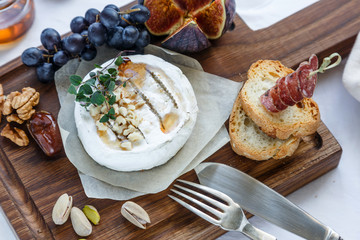 Camembert cheese with figs, honey and wine. Selective focus. Close view