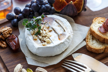 Camembert cheese with figs, honey and wine. Selective focus. Close view