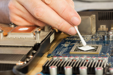 computer repair. applying thermal paste to the video processor. close-up selective focus