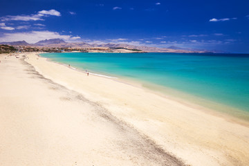 Fototapeta premium Costa Calma sandy beach with vulcanic mountains in the background, Jandia, Fuerteventura island, Canary Islands, Spain.