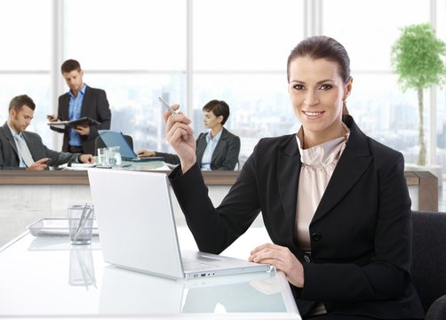 Middle-aged businesswoman with laptop at office