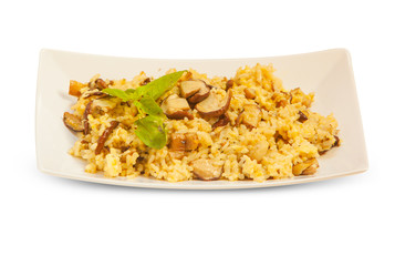  hot risotto with mushrooms on white plate on white background